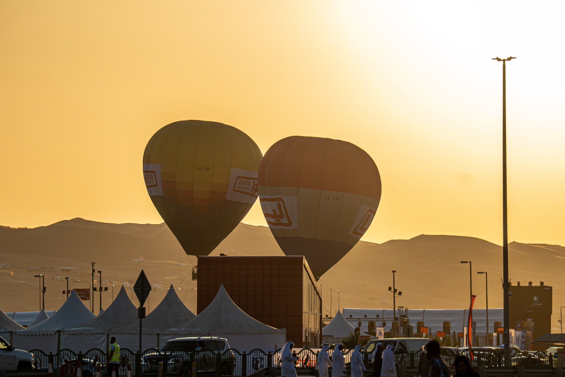 Hot-air balloons rising over Liwa Festival at sunset